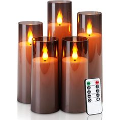 four lit candles with remote controls in front of them