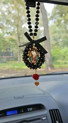 a car dashboard with a rosary hanging from it's dash board and the image of jesus