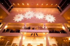 people are standing on the balconies in front of a large building with snowflakes hanging from it