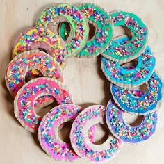 donuts with sprinkles are arranged in a circle on a table top