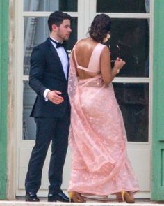 a man in a tuxedo standing next to a woman in a pink dress