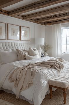 a bed with white linens and pillows in a bedroom