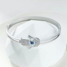 This opulent amulet in the shape of the Hand of Fatima and adorned with clear and blue cubic zirconia stones captures the lifetime wishes of the wearer and provides protection. Complete your look with this Hamsa Hand Bangle Bracelet crafted from high quality materials - perfect for any event or as a gift. It can be worn with any of our Balara Jewelry collection trendy bangle bracelets.- Stones Material: Cubic Zirconia. - Metal: Stainless Steel.- Plating: 18k Gold plated or Rhodium.- Interior Dia Evil Eye Bangle, Stainless Steel Plate, Hand Of Fatima, Gold Bangle Bracelet, Hamsa Hand, Gold And Silver, Bangle Bracelet, Evil Eye, Sapphire Ring