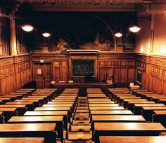 an empty classroom with wooden desks in it