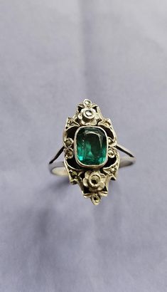 A gorgeous original Art Deco ring. Hallmarked sterling silver. A paste stone with the look of a beautiful emerald.  Studded with twinkling marcasites, with a tiny forget me not flower detail to the top & bottom. Ring size N, US size 7. The front of the ring is just over 2cm tall. Such an elegant shape ~ Art Deco Emerald Ring With Rose Cut Diamonds, Art Deco Green Emerald Ring With Rose Cut Diamonds, Vintage Green Rings With Stone Setting, Antique Green Emerald Cut Ring, Antique Green Emerald Cut Emerald Ring, Antique Green Emerald-cut Emerald Ring, Antique Emerald Cut Green Emerald Ring, Vintage White Gold Emerald Jewelry, Vintage Green Emerald Ring With Rose Cut Diamonds