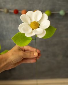 a person holding a fake flower in their hand