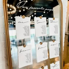 a gold framed mirror with seating cards attached to the front and back of each piece