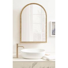 a white sink sitting under a mirror in a bathroom next to a wall mounted faucet