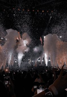 people are taking pictures with their cell phones as fireworks go off in the air