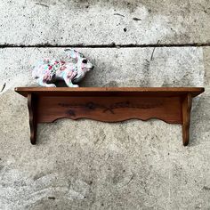 a wooden shelf with a stuffed animal on it