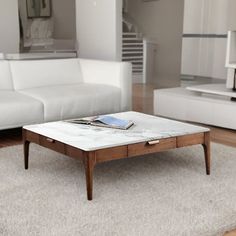 a living room with white couches and a coffee table in the middle of it