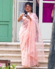 a woman in a pink sari is taking a selfie with her cell phone