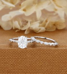 a close up view of a diamond ring on a table with flowers in the background