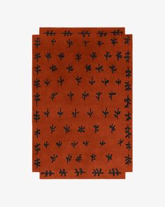 an orange rug with black cactus designs on the front and bottom, against a white background