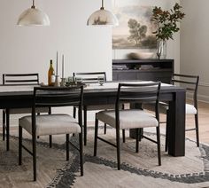 a dining room table and chairs with an area rug on the floor next to it