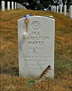 a headstone in the middle of a grassy field