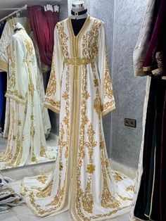 a white and gold dress on display in a store