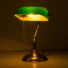 a green and yellow desk lamp sitting on top of a table