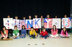 a group of children holding up signs with the words think and american flag on them