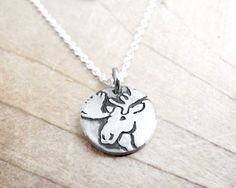 a small silver necklace with a moose head on it's back end and a chain that is attached to the neckline