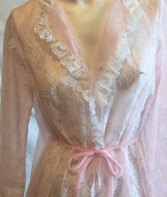 Found this at an estate sale. The women had many many many pieces of unworn lingerie. This is a piece by Miss Elaine. Sized as small but runs large. Chiffon base layer over a full lace cover. Ruffled sleeves and neck line. Tie waist.Lace covered buttons. Measures bust 38'' length 57'' Fitted Sheer Lace Robe, Fitted Lace Robe With Sheer Details, Fitted Vintage Robe For Daywear, Vintage Spring Robe For Home, Feminine Fitted Daywear Robe, Fitted Feminine Daywear Robe, Feminine Fitted Robe For Daywear, Fitted Feminine Robe For Daywear, Vintage Sheer Sleepwear