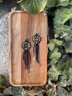 Beaded Boho Earrings, Huichol Earrings, Boho Colorful Flower Earrings, Indigenous Made, Traditional Beadwork, Seed Bead Fringe Earrings ♥𝑇ℎ𝑒 𝑝𝑎𝑡𝑡𝑒𝑟𝑛 𝑜𝑓 𝑡ℎ𝑖𝑠 𝑒𝑎𝑟𝑟𝑖𝑛𝑔 𝑖𝑠 𝑐𝑟𝑒𝑎𝑡𝑒𝑑 𝑏𝑦 𝐾𝑎𝑍𝑒𝐵𝑒𝑎𝑑𝐽𝑒𝑤𝑒𝑙𝑟𝑦 ♥𝑀𝑎𝑑𝑒 𝑢𝑠𝑖𝑛𝑔 𝑓𝑟𝑒𝑒ℎ𝑎𝑛𝑑 𝑏𝑒𝑎𝑑𝑖𝑛𝑔 𝑤𝑜𝑣𝑒𝑛 𝑡𝑒𝑐ℎ𝑛𝑖𝑞𝑢𝑒𝑠 𝑤𝑖𝑡ℎ 𝑠𝑡𝑟𝑜𝑛𝑔 𝑠𝑦𝑛𝑡ℎ𝑒𝑡𝑖𝑐 𝑡ℎ𝑟𝑒𝑎𝑑. ♥𝑇ℎ𝑒 𝑠𝑖𝑧𝑒 𝑜𝑓 𝑡ℎ𝑒 𝑠𝑒𝑒𝑑 𝑏𝑒𝑎𝑑𝑠 𝑢𝑠𝑒𝑑 𝑖𝑠 2 𝑚𝑖𝑙𝑙𝑖𝑚𝑒𝑡𝑒𝑟𝑠 𝑎𝑛𝑑 𝑏𝑒𝑎𝑑𝑠 𝑎𝑟𝑒 ℎ𝑖𝑔ℎ 𝑞𝑢𝑎𝑙𝑖𝑓𝑖𝑒𝑑. ♥𝐴𝑙𝑙 𝑡ℎ𝑒 ℎ𝑜𝑜𝑘𝑠 𝑢𝑠𝑒𝑑 𝑖𝑛 𝑜𝑢𝑟 𝑗𝑒𝑤𝑒𝑙𝑟𝑦 𝑎𝑟𝑒 24 𝑘 𝑔𝑜𝑙𝑑 𝑝𝑙𝑎𝑡𝑒𝑑 𝑎𝑛𝑑 ℎ𝑦𝑝𝑜𝑎𝑙𝑙𝑒𝑟𝑔𝑒𝑛𝑖𝑐. ♥𝑇ℎ𝑒𝑠𝑒 𝑎𝑟𝑒 𝑣𝑒𝑟𝑦 𝑙𝑖𝑔ℎ𝑡 𝑒𝑎𝑟𝑟𝑖𝑛𝑔𝑠 𝑡ℎ𝑎𝑡 𝑦𝑜𝑢 𝑐𝑎𝑛 𝑤𝑒𝑎𝑟 𝑎𝑙𝑙 𝑑𝑎𝑦 𝑤𝑖𝑡ℎ𝑜𝑢𝑡 ℎ𝑢𝑟𝑡𝑖𝑛𝑔 𝑦𝑜𝑢𝑟 𝑒𝑎𝑟! The only a Festival Black Bead Drop Earrings, Black Bead Dangle Earrings For Festivals, Handmade Multicolor Flower Earrings With Round Beads, Black Beads Dangle Earrings For Festival, Black Beaded Dangle Earrings For Festivals, Beach Dangle Earrings With Black Beads, Bohemian Multicolor Flower Earrings With Colorful Beads, Multicolor Flower-shaped Earrings With Colorful Beads, Bohemian Flower Shaped Colorful Beaded Earrings