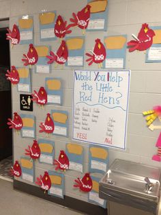 a bulletin board is decorated with red and yellow paper birds, which are hanging on the wall