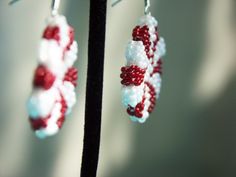 Embrace this holiday season with these adorable peppermint candy earrings! These double sided earrings feature the iconic peppermint swirl pattern and are about an inch in diameter and about a quarter of an inch thick. These are hand beaded with red and rainbow white seed beads. These earrings make the perfect gift! *They are available in clip on or hook earring. If you would like the clip on option, please leave me a note upon purchase and I will exchange it for no extra cost. *More colors comi Candy Cane Seed Bead Earrings, Candy Cane Beaded Earrings, White Round Beaded Earrings As Gift, White Round Beaded Earrings For Gift, White Beaded Round Earrings For Gift, White Earrings With Tiny Beads, White Round Earrings With Tiny Beads, Candy Earrings, Double Sided Earrings