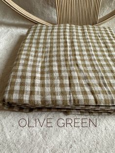 an image of a bed with the words olive green on it and a checkered pillow