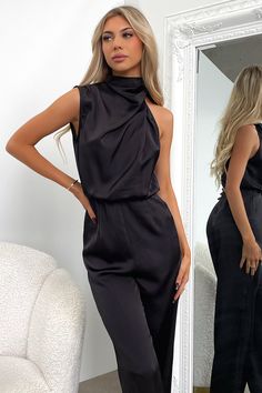 Sophisticated and classy, in the gorgeous Santorini Jumpsuit! She features a high neckline with an asymmetrical sleeve cut, long flared pants, silky soft material and a little cut out detail at the back with a button + zip closure. Match her with Black Heels and a bold Red lippy. FABRICATION: 100% polyester SIZING: Olivia's height is 163cm and wears a size AU6/US2. Chic Satin Jumpsuits And Rompers In Solid Color, Chic Solid Color Satin Jumpsuits And Rompers, Fitted Satin Jumpsuits And Rompers For Work, Elegant Stretch Pantsuit For Parties, Elegant Satin Jumpsuits And Rompers For Workwear, Elegant Satin Jumpsuit Or Romper In Solid Color, Solid Satin Jumpsuits And Rompers For Night Out, Chic Formal Satin Jumpsuits And Rompers, Elegant High Neck Jumpsuit For Night Out