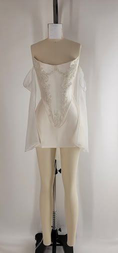 a mannequin wearing a white dress on display