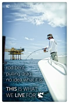 a man standing on top of a boat while holding a fish in it's mouth