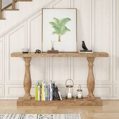 a wooden table with books on it in front of a stair case next to a staircase