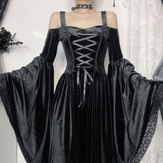 Indulge in the luxurious elegance of our Black Gothic Velvet Lace Up Bell Sleeve Maxi Dress. Made from soft velvet fabric, this dress features a corset-style lace-up front for a flattering, adjustable fit. The dramatic bell sleeves with intricate lace trim add a gothic-inspired charm, while the cold-shoulder design gives it a modern, sultry edge. With its flowing maxi length silhouette, this dress exudes regal and dramatic vibes, perfect for gothic events, formal occasions, or costume parties. Elevate your wardrobe with this exclusive statement piece. Soft velvet fabric for a luxurious feel Corset-style lace-up front for an adjustable fit Dramatic bell sleeves with lace trim for a gothic touch Cold-shoulder design for a sultry, modern edge Flowing maxi length for a regal silhouette Off Shoulder Bell Sleeve Dress, Sleeves With Lace, Costume Parties, Velvet Lace, Sleeve Maxi Dress, Corset Style, Maxi Dress With Sleeves, Shoulder Design, Soft Velvet