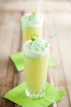 two glasses filled with ice cream on top of green napkins