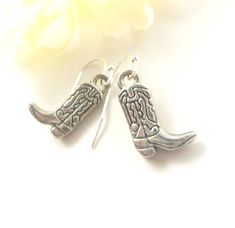 "🤠 Saddle Up in Style with Our Cowboy Boot Charm Earrings! 🤠 Yeehaw, cowgirl! Embrace your inner rodeo queen with our delightful Cowboy Boot Charm Earrings. Handcrafted with love and attention to detail, these earrings feature adorable miniature cowboy boots that dangle playfully from your ears. Key Features: 🌟 Charming Design: These earrings boast intricately designed cowboy boot charms, capturing the essence of the Wild West in every detail. 🌟 Quality Craftsmanship: Expertly crafted with h Nickel-free Western Style Earrings, Western Style Earrings For Gifts, Nickel-free Adjustable Western Earrings, Adjustable Nickel-free Western Earrings, Wild West Fashion, Boot Charm, Boot Charms, Texas Western, Rodeo Queen