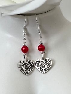 Red pearl and heart drop earrings. Add a touch of elegance to your wardrobe with these timeless earrings. Handmade with love to elevate any look or outfit.  Sterling silver ear hooks with a red faux Pearl and heart drop design.    Free shipping to UK buyers. Dispatched within 1-3 days but I aim for next day postage.  Presented on a gift card and wrapped beautifully to make these the prefect gift for loved ones.  If you aren't completely in LOVE with your purchase, please let me know and you'll receive a stress free refund. Customer satisfaction Is my main priority.  These are perfect for any occasion. Thank you for viewing and supporting a small business.  Please ask any questions, I am always available to help.  If you have a spare moment please view my other pieces in my shop.  Kind rega Silver Heart-shaped Pearl Earrings For Valentine's Day, Heart-shaped Pearl Earrings For Valentine's Day, Silver Heart Earrings With Pearl Drop, Elegant Red Heart Charm Earrings, Elegant Red Earrings With Heart Charm, Elegant Red Double Heart Earrings, Elegant Red Heart Earrings For Gift, Valentine's Day Heart Earrings With Pearl Drop, Elegant Heart Bead Drop Earrings