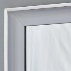 a white framed mirror hanging on the wall