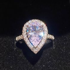 This Stunning Water Drop Simulated Diamond Ring Set In A Tension Mount Has A 3.47ct Center Stone With .5ct Halo White Gold Plated Silver Ring & Stamped S925. This Stones Show Quality Is Almost Indescribable, The Photos Can’t Even Pick Up All The Rainbow & Kaleidoscope Colors It Shows. The Photos Posted Show White, Purple, Pink & Silver But Are Missing The Beautiful Blues. Even The Mount Is Gorgeous! Size 6,7,8,9 Diamond White Teardrop Jewelry For Proposal, Teardrop Diamond White Jewelry For Proposal, White Gold Teardrop Jewelry For Proposal, Elegant White Crystal Heart Cut Ring, Silver Pear-shaped Jewelry For Proposal, Pear-shaped Halo Setting Jewelry For Promise, Silver Teardrop Jewelry For Proposal, Diamond White Halo Ring With Cubic Zirconia Gemstone, Halo Ring With Prong Setting For Proposal