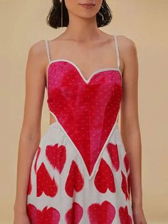 a woman in a red and white dress with hearts painted on the back of it