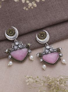 Dive into the realm of sophistication and charm with our Dual Tone Pink Chandbali Earrings, a harmonious blend of tradition and contemporary flair. These earrings boast a graceful design adorned with exquisite half-moon detailing, showcasing the artisanal finesse that makes them a true embodiment of elegance. The dual tone pink color palette imparts a refreshing and playful vibe, making them a versatile accessory that effortlessly transitions from day to night, from casual gatherings to festive celebrations. Meticulously crafted with precision, these earrings not only serve as a visual delight but also symbolize a timeless statement piece. Elevate your style effortlessly as you embrace the fusion of classic and modern aesthetics, allowing these Dual Tone Pink Chandbali Earrings to become a Metal Chandbali Bridal Earrings, Festive Dual-tone Chandbali Jewelry, Dual-tone Chandbali Jewelry For Festive Season, Fusion Style Chandbali Brass Jhumkas, Brass Chandbali Bridal Earrings, Fusion Style Tilla Chandbalis Drop Earrings, Festive Metal Temple Jewelry Chandbalis, Festive Brass Chandbali Danglers, Metal Chandbali Danglers With Intricate Design