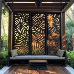 a room divider made out of wood and metal with tropical leaves on the screen