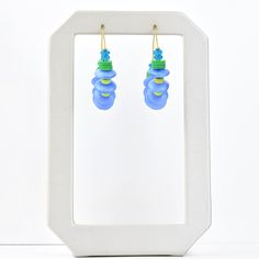 Made in the USA Brass hoops Kelly green, aqua and blue beads Earrings hang 1.5 inches Want to see more of this collection? David Aubrey lines vary from delicate, meticulously assembled jewelry of monochromatic hues to larger, more vibrant pieces. Some collections are themed, whether romantic, vintage, tribal, or art deco. Each piece is painstakingly crafted with an array of raw materials, including plated and oxidized brass and white metal, semiprecious stones, vintage glass beads, Indian handma Adjustable Blue Hoop Earrings With Dangling Beads, Blue Hoop Earrings With Dangling Beads Gift, Adjustable Blue Jewelry Made Of Recycled Glass, Blue Glass Jewelry With Dangling Beads, Adjustable Blue Recycled Glass Jewelry, Adjustable Blue Jewelry With Recycled Glass, Blue Recycled Glass Nickel-free Earrings, Blue Hoop Earrings With Ear Wire For Beach, Blue Nickel-free Recycled Glass Earrings