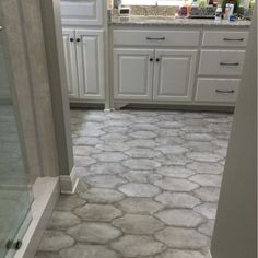 a bathroom with white cabinets and gray stone flooring