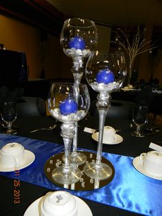 there are three wine glasses on top of each other with blue balls in the middle