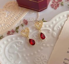 Valentine's Day romantic vibes, dainty heart shaped gold lace stud with red ruby dangle earrings. Stunning red zircon gemstones show elegant, classy and lovely sparkles. Perfect for your dates, happy time out or a accent spice to elevate your style! 💎 Features: ♥ Material: Gold plated bronze and sterling silver ♥ Main stone: Red ruby zircon ♥ Push back Closure 💎 Details: ♥ Approximate Measurements: - Length: 3 cm ♥ Lightweight, easy to wear ♥ Nickel/Lead Free, Hypoallergenic 🎁 Packing & Shipping: ♥ All our jewelry will be shipped with beautiful gift wrap packaging ♥ Handwrite gift notes/cards available upon request ♥ SAME DAY & FREE US Domestic Shipping available ♥ International customers: We ship worldwide! But we are not responsible for customs duties/taxes. 💎 Thank you for your supp Dainty Earrings For Valentine's Day Party, Dainty Valentine's Day Party Earrings, Teardrop Earrings For Valentine's Day Party, Red Heart Cut Elegant Earrings, Elegant Red Double Heart Earrings, Elegant Teardrop Heart Earrings For Valentine's Day, Elegant Red Heart Cut Earrings, Valentine's Day Elegant Teardrop Heart Earrings, Elegant Red Heart Earrings For Gift