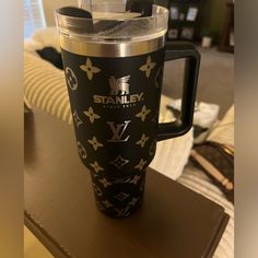 a black and gold travel mug sitting on top of a table