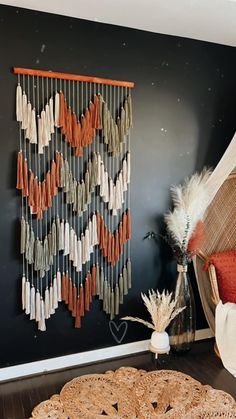 a room with a chair, rug and wall hangings on the wall in front of it