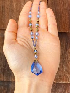 The loop of the clasp on this necklace is marked, 'Czechoslovakia' and it feels old and well made when held. The glass is a periwinkle blue and there is a faceted teardrop pendant at the bottom with a decorative metal top. The beads on the strand are both small and round, and long and cylindrical. There are also small, spherical, gold toned beads with a swirled texture. There is some corrosion around the clasp and a small chip on the pendant. The necklace is being sold As Is for this reason. It Vintage Necklace With Polished Beads, Vintage Czech Glass Necklaces With Polished Beads, Vintage Czech Glass Necklace With Polished Beads, Vintage Czech Glass Necklace With Faceted Beads, Vintage Czech Glass Polished Beads Necklace, Vintage Faceted Crystal Necklaces For Gifts, Blue Costume Jewelry Necklaces With Lobster Clasp, Vintage Czech Glass Beaded Necklaces With Polished Beads, Antique Beaded Necklace With Faceted Beads As Gift