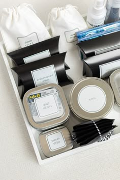 an assortment of personal care items are displayed on a white tablecloth with black and silver accents